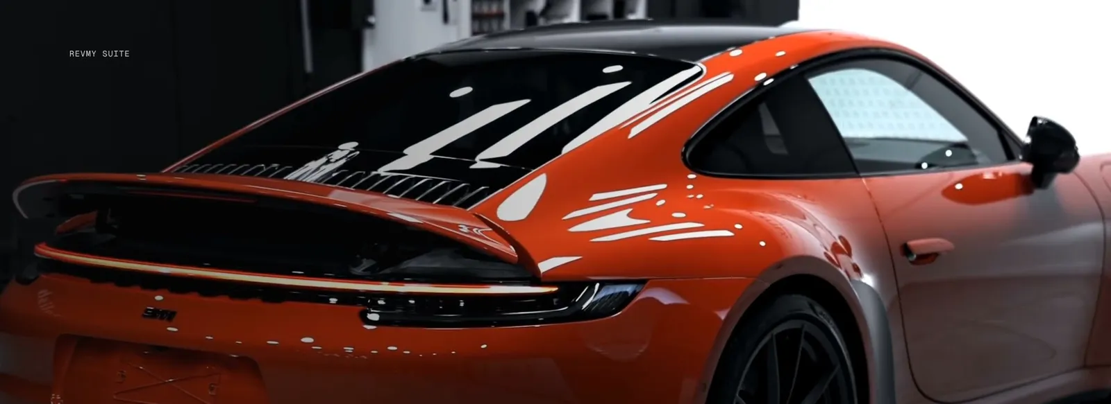 Porsche 911 portocaliu, partea din spate, în atelier
